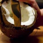 Cutting open a coconut to make desiccated coconut