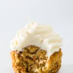 One carrot cake cupcake with a bite taken out of it