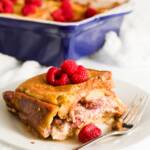 Slice of raspberry stuffed French toast with the casserole dish in the background