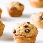 Banana oatmeal chocolate chip muffins scattered on a white background