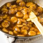 a skillet of caramelized bananas with a spatula