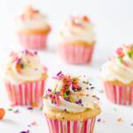 A group of mini cupcakes in pink and white liners