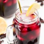 A glass of iced hibiscus tea garnished with lemon