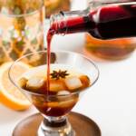 homemade grenadine being poured into a bourbon cocktail