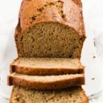 A loaf of zucchini bread with slices falling off the front of it