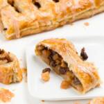 Apple strudel with a slice cut off and placed on a square white plate