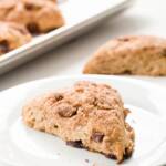 Cinnamon scone on a white plate with scones in the background