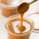 two jars of cajeta with a spoon full of the caramel drizzling back into one