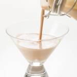 tight shot of homemade Baileys being poured into short martini glass