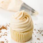 cupcake topped with coffee frosting and a piping bag in the background