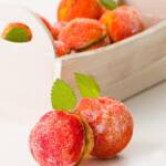 Two peach cookies in the foreground with a basket of cookies in the background