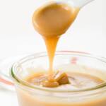 Butterscotch dripping off a spoon into a jar