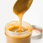 Whiskey sauce being poured into a jar from a spoon