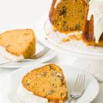 Glazed sweet potato cake on a cake stand with several pieces on white plates in front of it