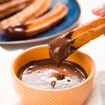 Dipping a churro into Mexican Chocolate Sauce