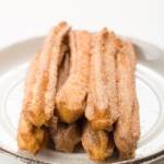 Stack of churros on a white plate