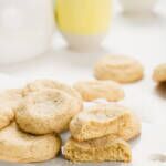 Pile of vanilla cookies with tea setup behind