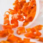 A spilled plastic container of candied carrot curls.